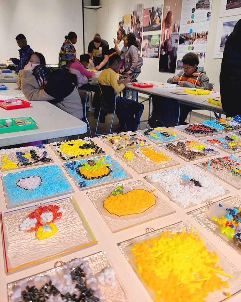 6th graders glass artwork with students in background working