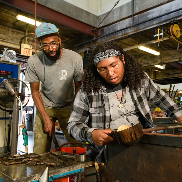 two people working on blown glass project