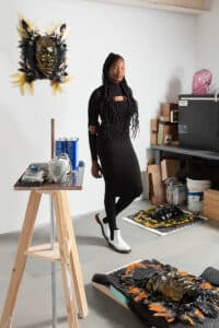 Woman in black dress standing in art studio