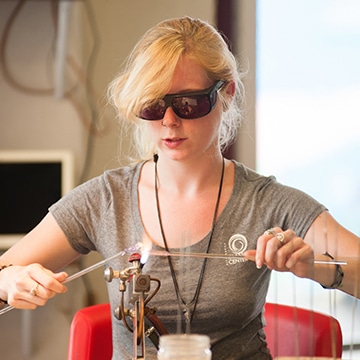 person working with flame and glass