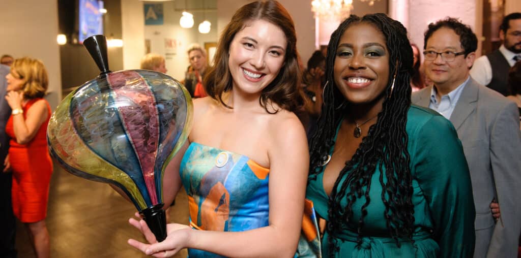 two people holding glass art