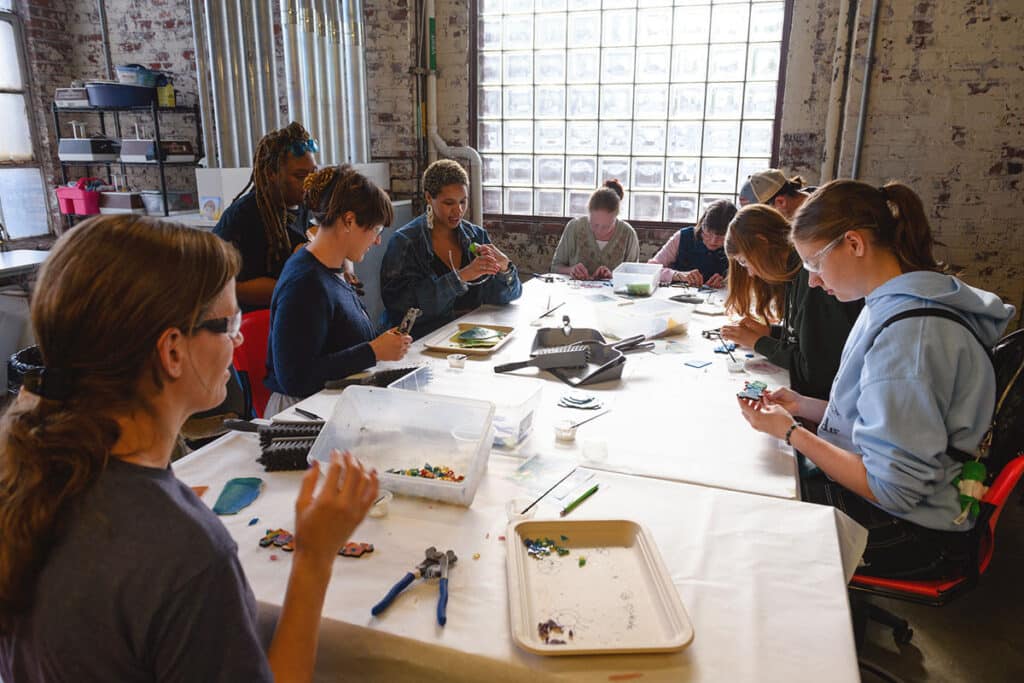 Visitors working on a collaborative mosaic activity at Pittsburgh Glass Center