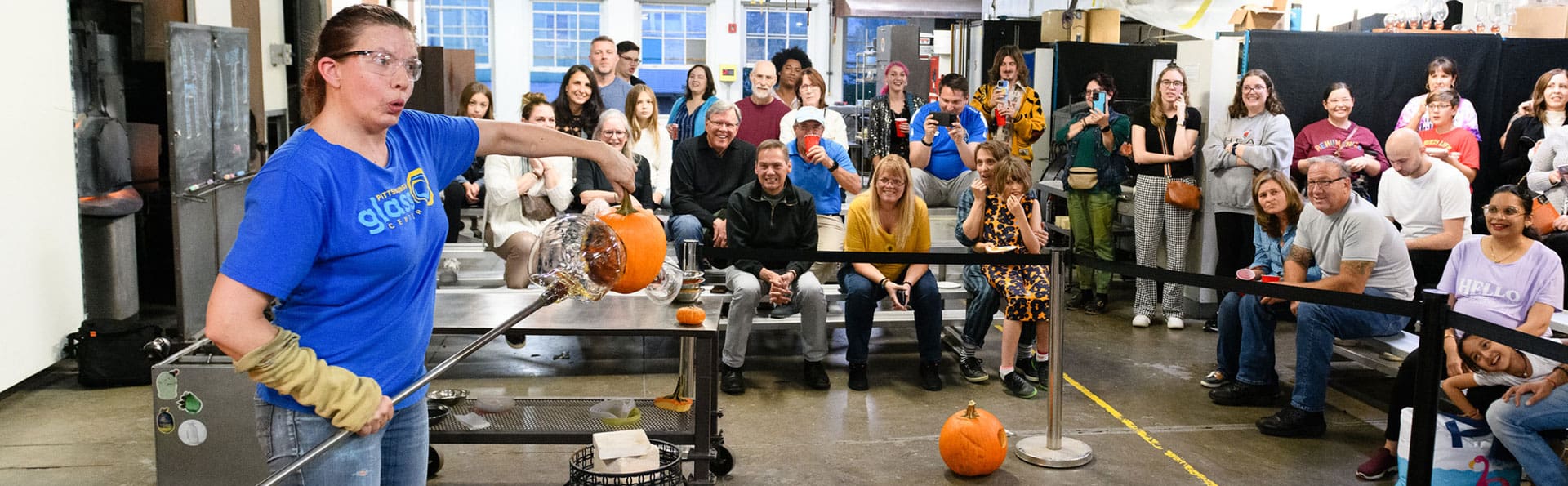 Quade blowing molten glass into carved pumpkins