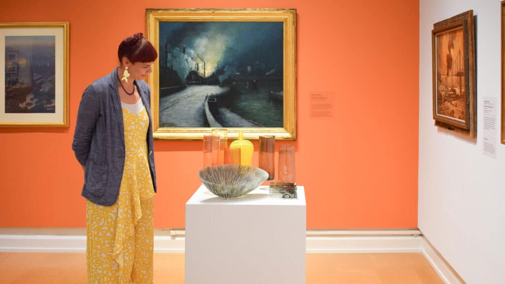 woman looking at a glass display at the Westmoreland Museum of American Art